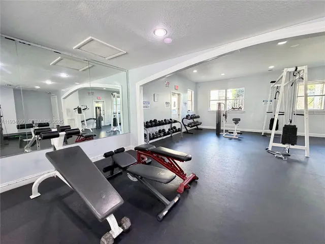 a room with gym equipment and a view of living room