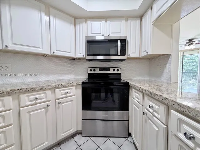 a kitchen with white cabinets and stainless steel appliances