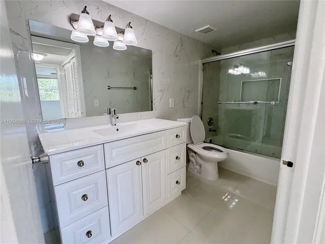 a bathroom with a double vanity sink mirror and toilet