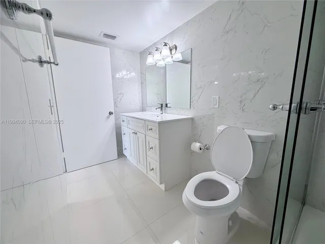 a spacious bathroom with a toilet sink and mirror