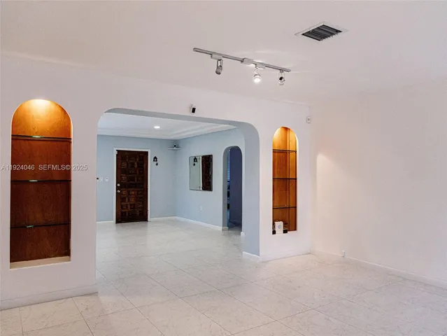 an empty room with fireplace and windows