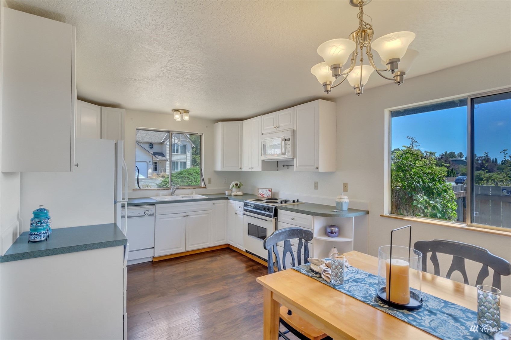 22420 13th Place West Bothell, WA 98021 - Photo 6 of 19 a kitchen with a stove a sink a dining table and chairs