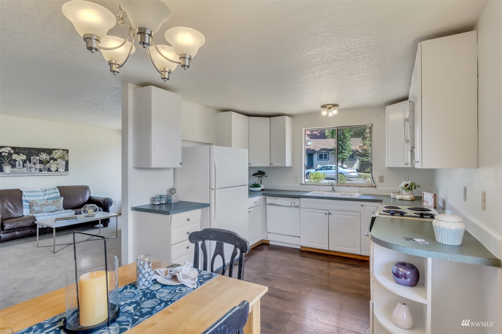 22420 13th Place West Bothell, WA 98021 - Photo 7 of 19 a kitchen with stainless steel appliances granite countertop a sink dishwasher a stove a dining table and chairs with wooden floor