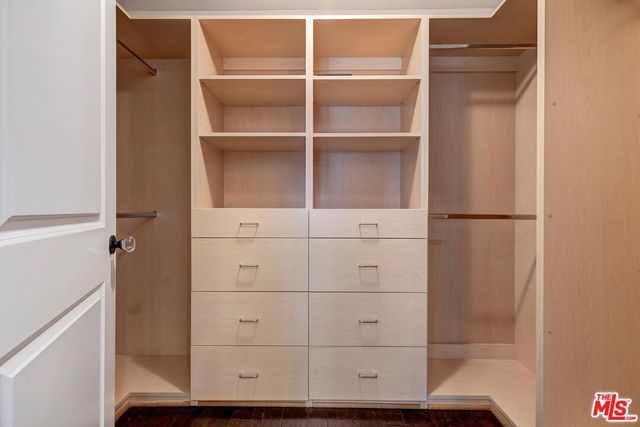 a view of walk in closet with empty racks
