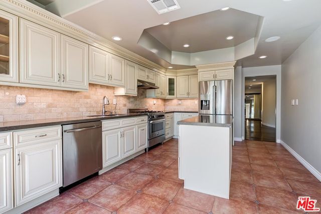 a kitchen with a refrigerator and a stove top oven