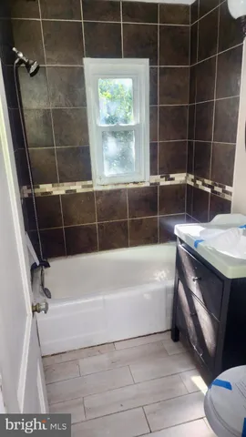 a bathroom with a bathtub a window and a shower