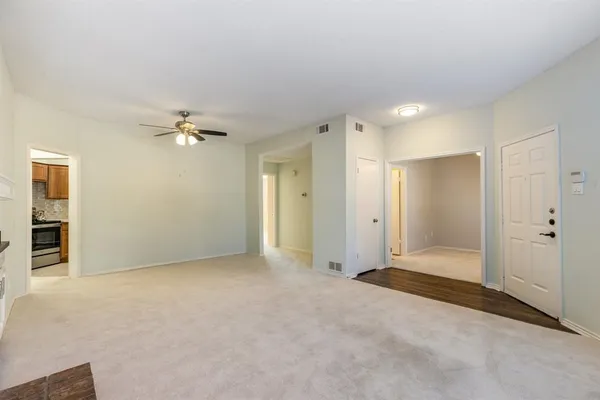 an empty room with closet and a ceiling fan