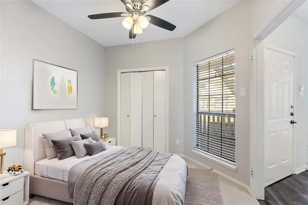 an empty room with windows and fan