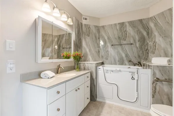 a bathroom with a granite countertop sink and a mirror