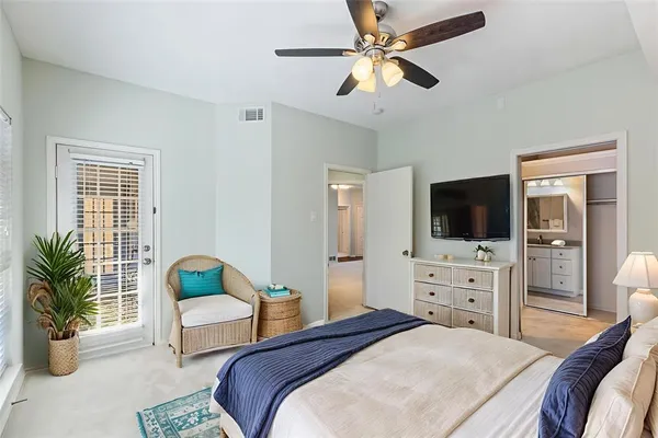 a bedroom with a bed a couch and a flat screen tv