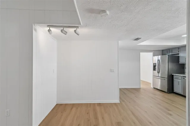 a view of a kitchen with a wooden floor and a refrigerator