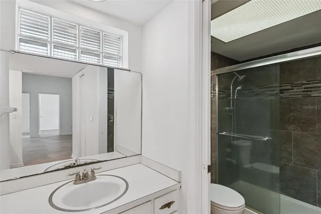 a bathroom with a sink a toilet and shower