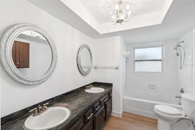 a bathroom with a granite countertop toilet a sink and a mirror