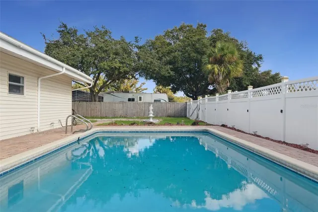 a view of a backyard with a large tree and wooden fence