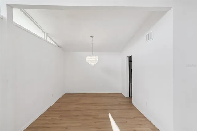 a view of a room with wooden floor and white walls