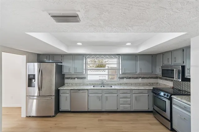 a kitchen with stainless steel appliances a refrigerator sink and microwave