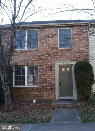 a brick building with a door and a yard