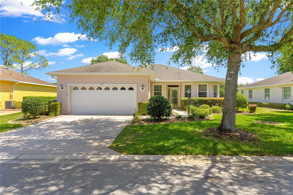 9317 Southwest 94th Loop Ocala, FL 34481 - Photo 38 of 40 a front view of a house with a garden and yard