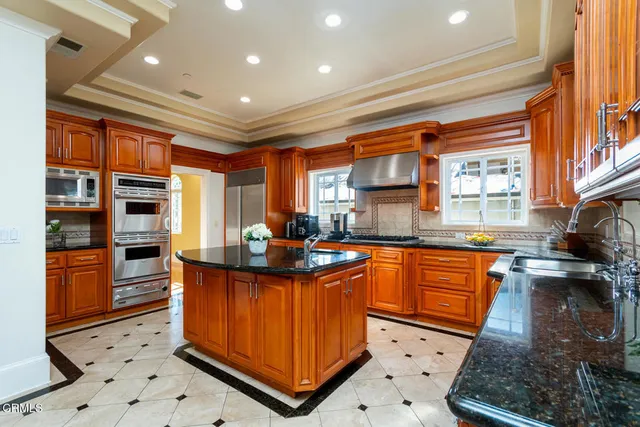 a kitchen with stainless steel appliances kitchen island granite countertop a sink and cabinets