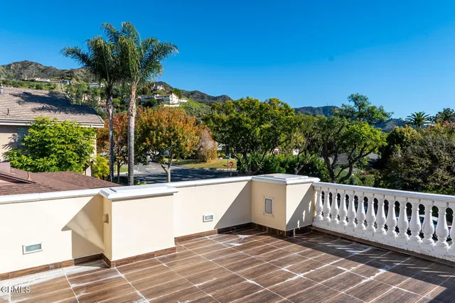 a view of a patio with couches table and chairs under an umbrella