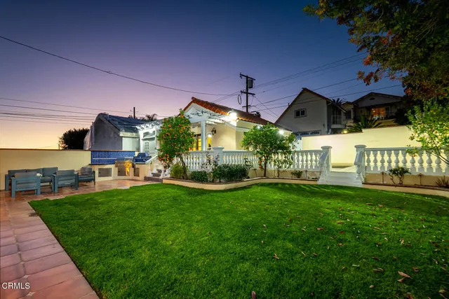a backyard of a house with table and chairs