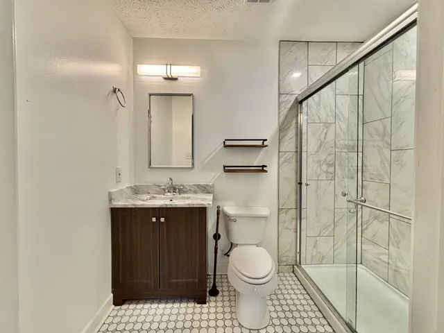 a bathroom with a sink a toilet and shower