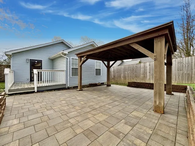 a backyard of a house with table and chairs