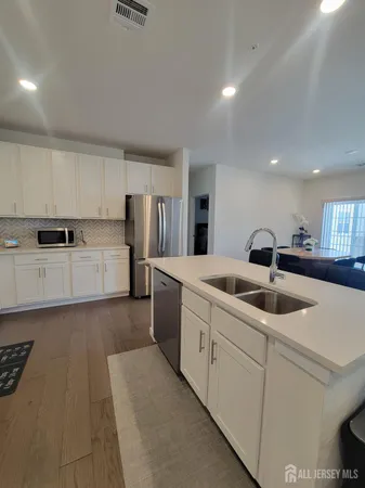 a kitchen with stainless steel appliances granite countertop a sink and white cabinets