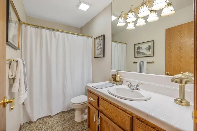 a spacious bedroom with a bed and a chandelier