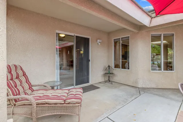 an outdoor view of a house with swimming pool and furniture