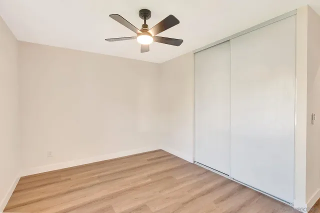 an empty room with window and ceiling fan