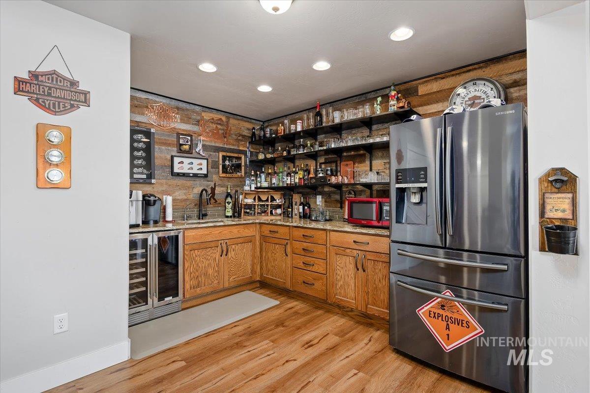 40 Bell Rapids Road Hagerman, ID 83332 - Photo 17 of 50 Indoor wet bar featuring stainless steel refrigerator with ice dispenser, wood finish cabinets, wine cooler, open shelves, and recessed lighting