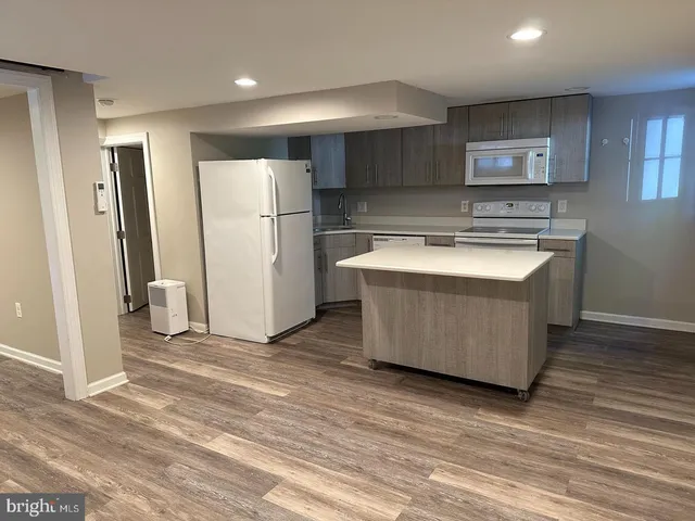 a kitchen with stainless steel appliances granite countertop a refrigerator a sink and a stove