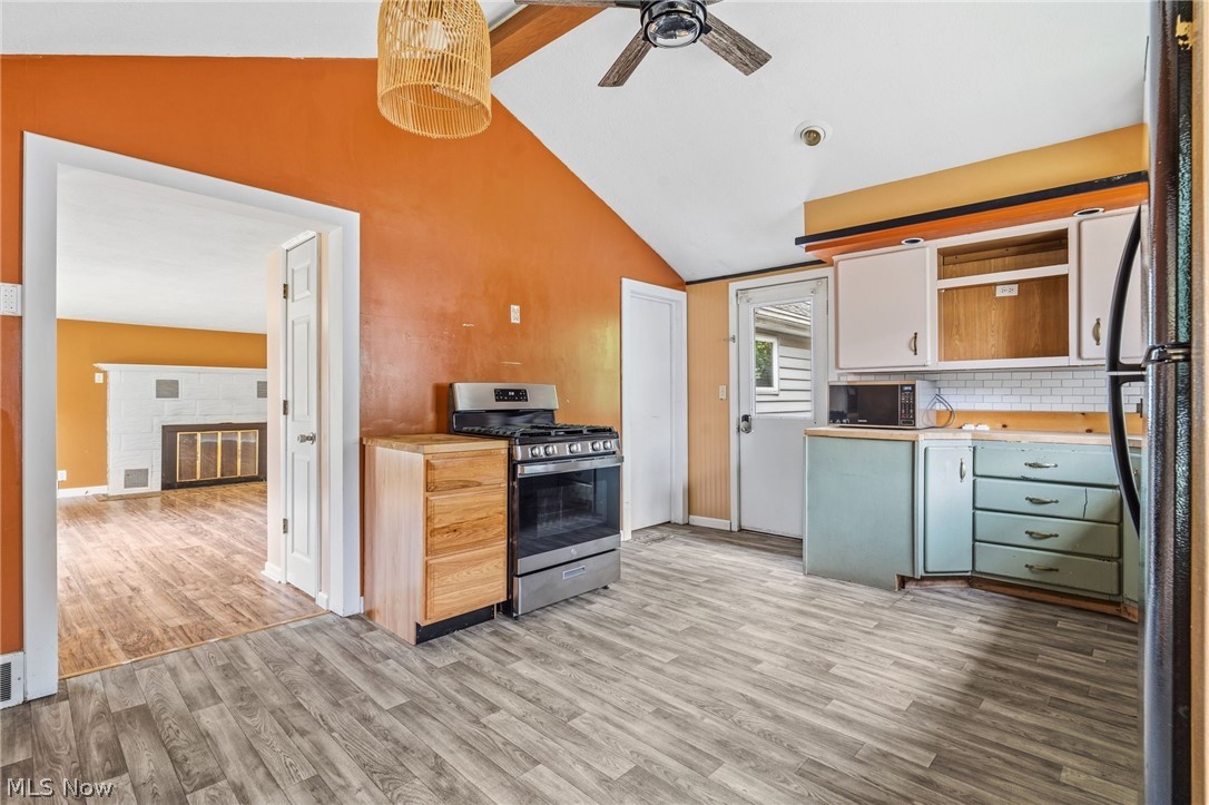 4449 18th Street Northwest Canton, OH 44708 - Photo 9 of 25 Kitchen featuring wood-finish flooring, vaulted ceiling, and a stainless steel range