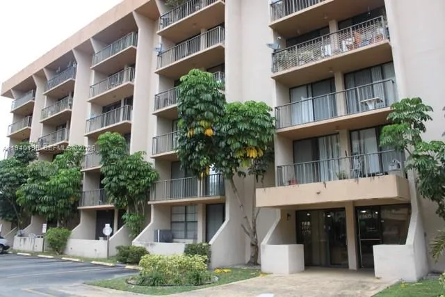 a front view of a building with a garden and plants
