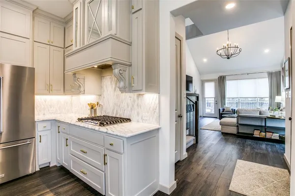 a kitchen with a stove a refrigerator and a view of living room