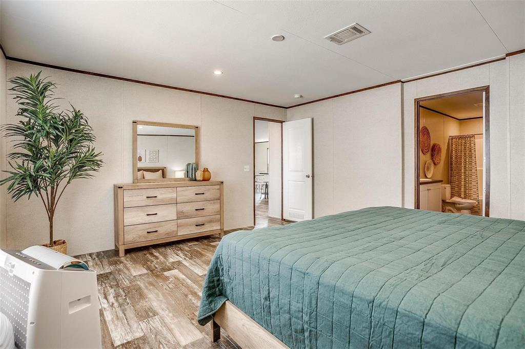 242 Huddleston Road Sunset, TX 76270 - Photo 12 of 18 a bedroom with a bed and a potted plant