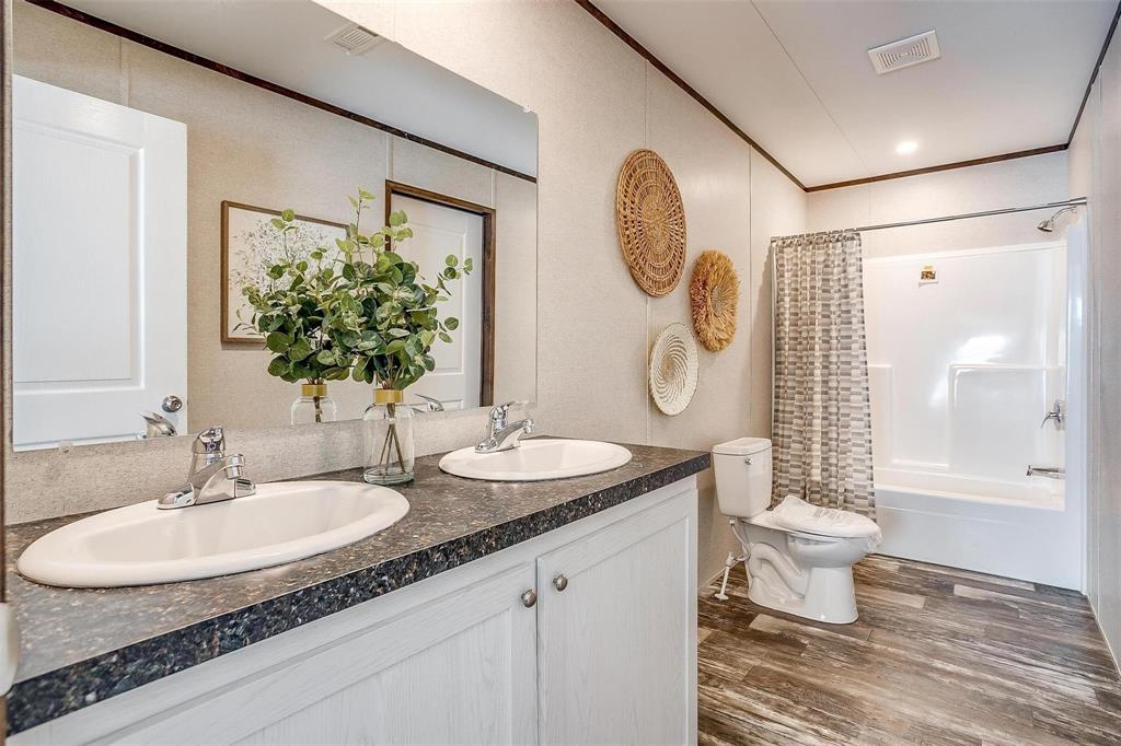 242 Huddleston Road Sunset, TX 76270 - Photo 14 of 18 a bathroom with a granite countertop sink toilet and a mirror