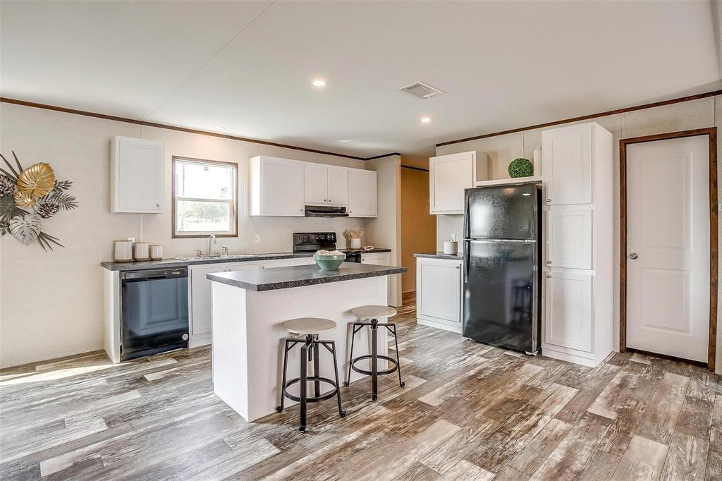 242 Huddleston Road Sunset, TX 76270 - Photo 6 of 18 a kitchen with granite countertop a refrigerator stove top oven and sink