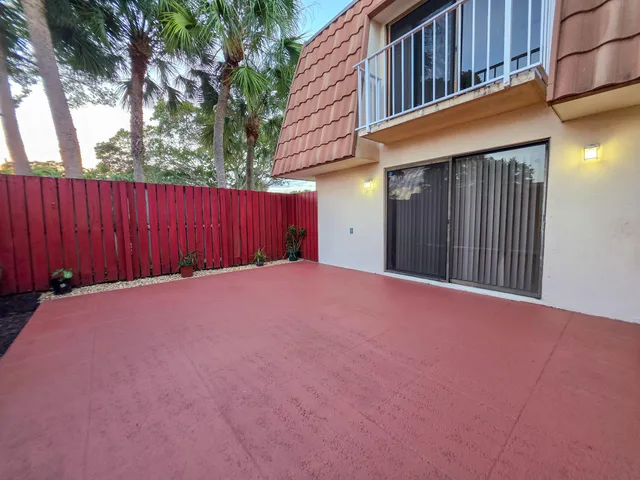 a view of a house with backyard and wooden fence