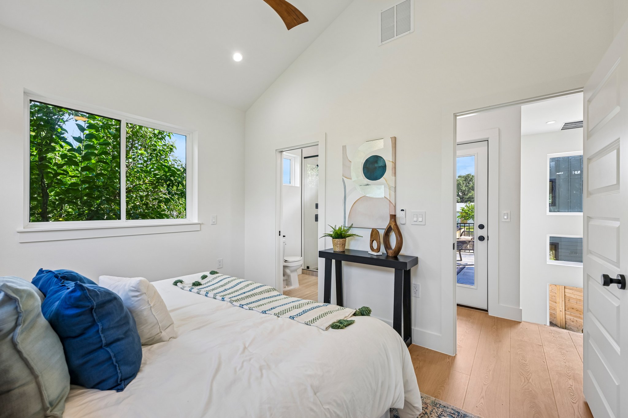 513 West Odell Street, Unit B Austin, TX 78752 - Photo 16 of 38 Natural light floods this inviting bedroom, highlighting the smooth wood look floors and vaulted ceilings.