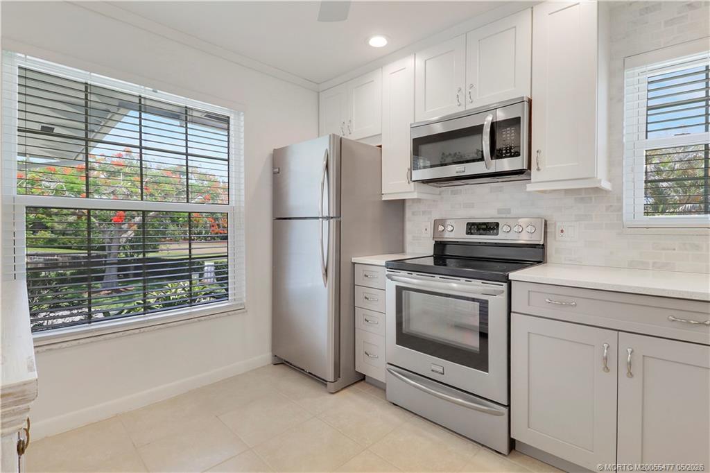 1852 Southwest Palm City Road, Unit 201 Stuart, FL 34994 - Photo 13 of 34 a kitchen with stainless steel appliances a stove a microwave sink and refrigerator