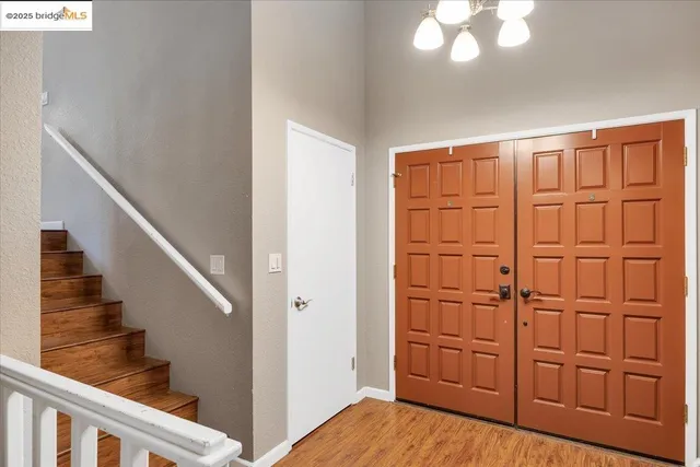 a kitchen with stainless steel appliances granite countertop a sink dishwasher a dining table and chairs with wooden floor