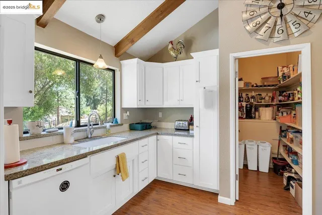 a kitchen with stainless steel appliances granite countertop a stove and white cabinets