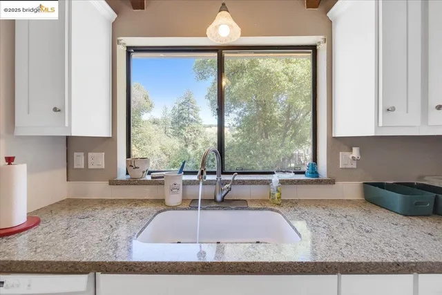 a kitchen with granite countertop white cabinets and white appliances