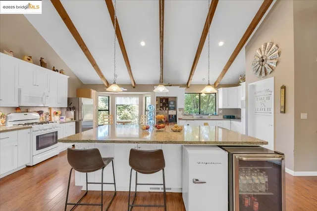 a bedroom with a large bed a large window with table and chair