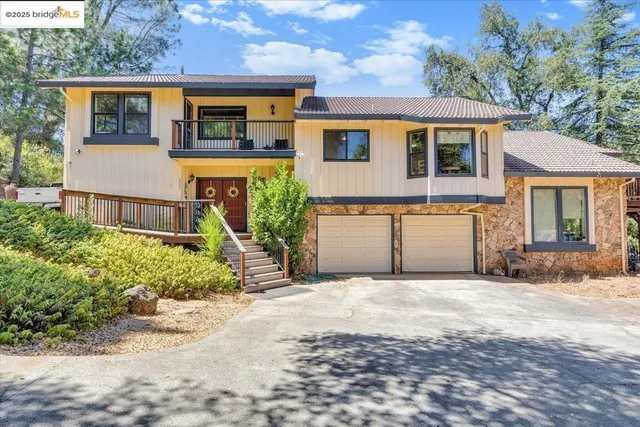 a front view of a house with a yard and potted plants