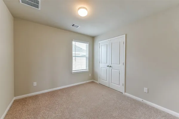 an empty room with windows and closet