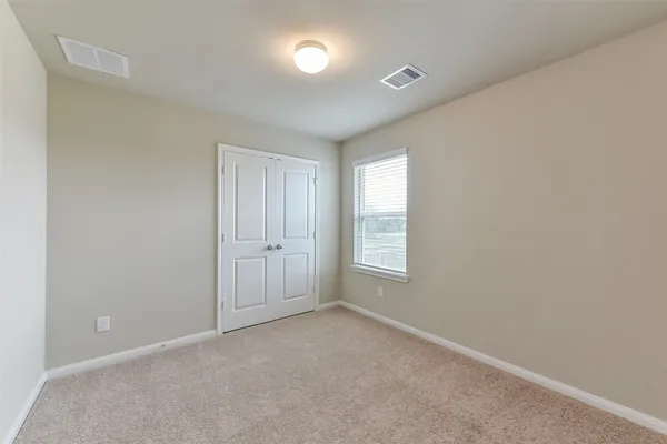 an empty room with windows and closet