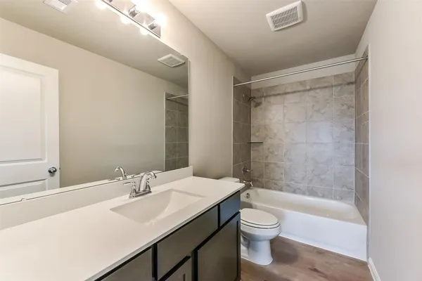 a bathroom with a granite countertop sink toilet a shower and a mirror